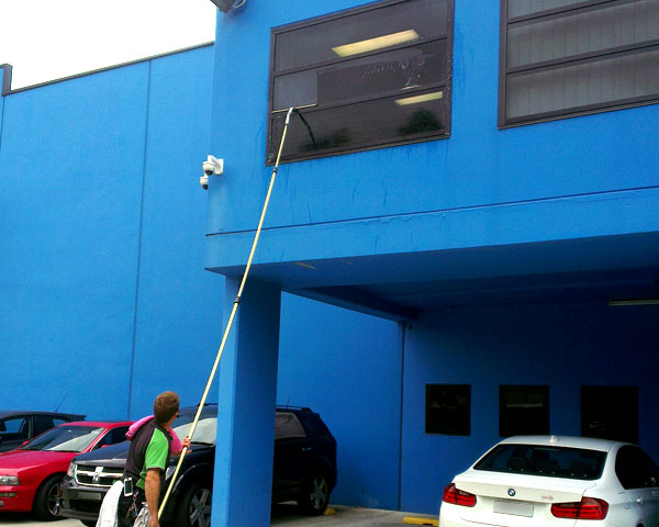 Camden Window Cleaning doing window cleaning with a pole for higher windows at a business in the Ingleburn industrial area
