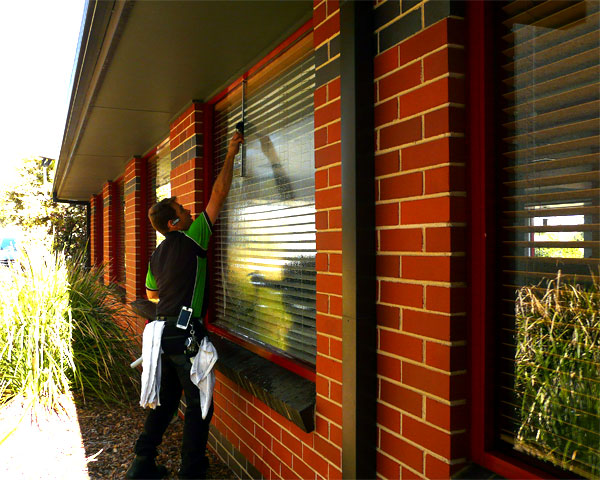 Camden Window Cleaning cleaning windows on the outside of a restaurant in St Andrews